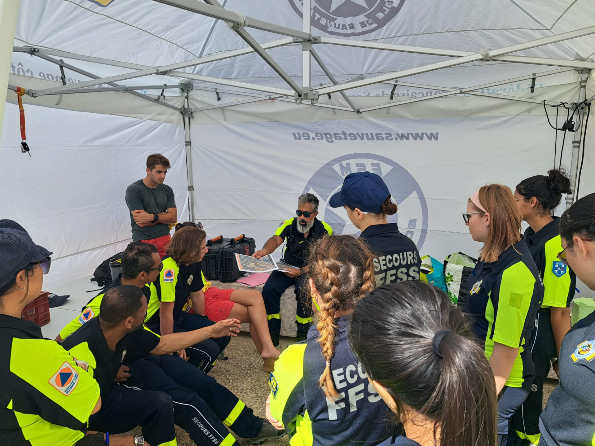 Équipe ESM en briefing opérationnel sous une tente